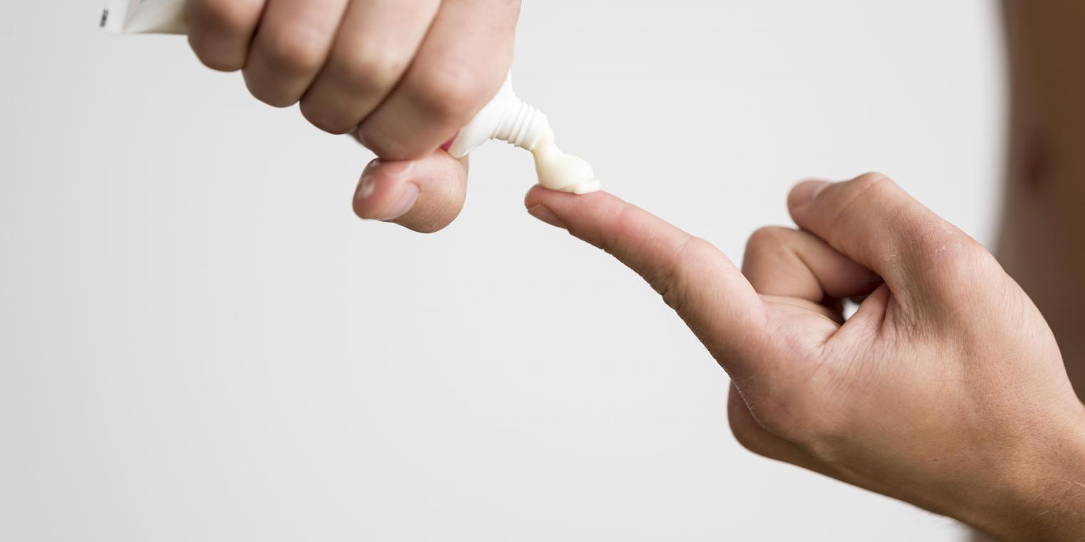 man-squeezing-cream-from-tube-his-finger man-squeezing-cream-from-tube-his-finger